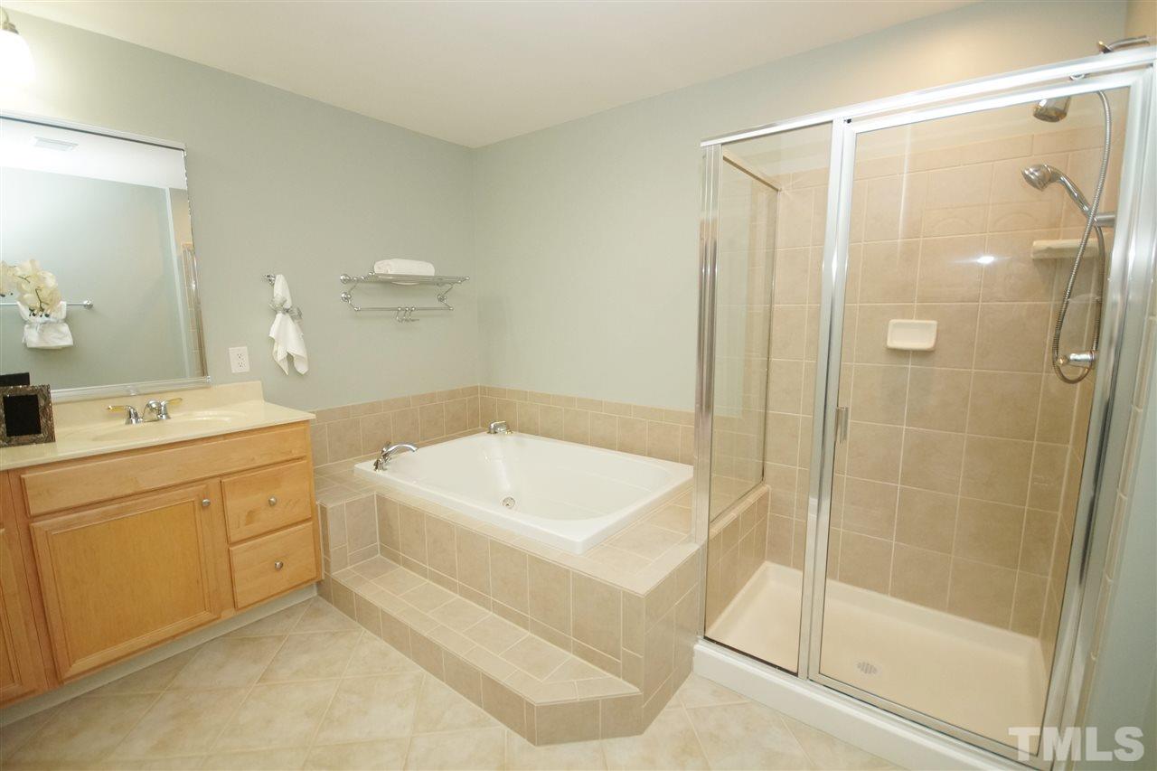 11032 Fair Chase Court Raleigh, NC 27617 - Photo 17 of 25 a spacious bathroom with a shower a sink and a mirror