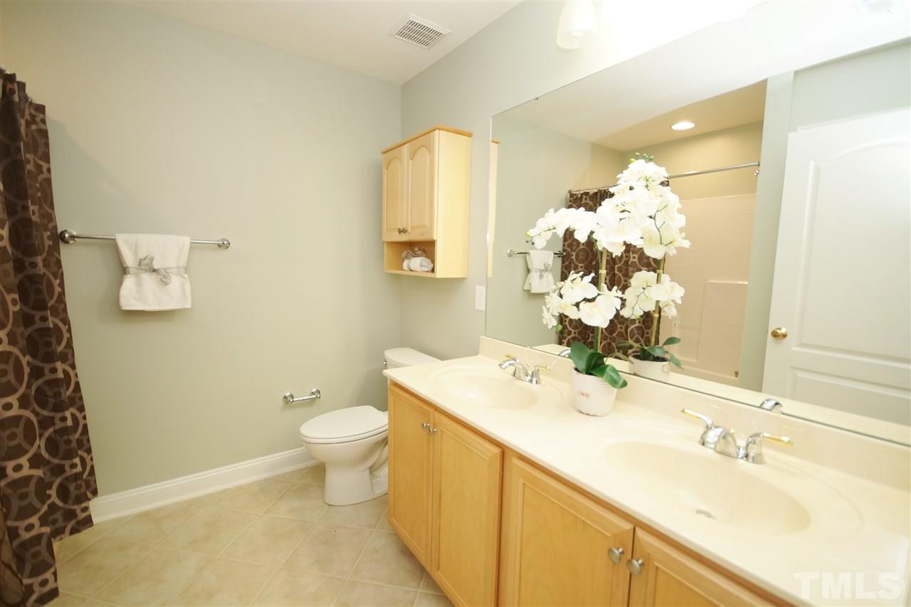 11032 Fair Chase Court Raleigh, NC 27617 - Photo 20 of 25 a bathroom with a sink mirror and toilet