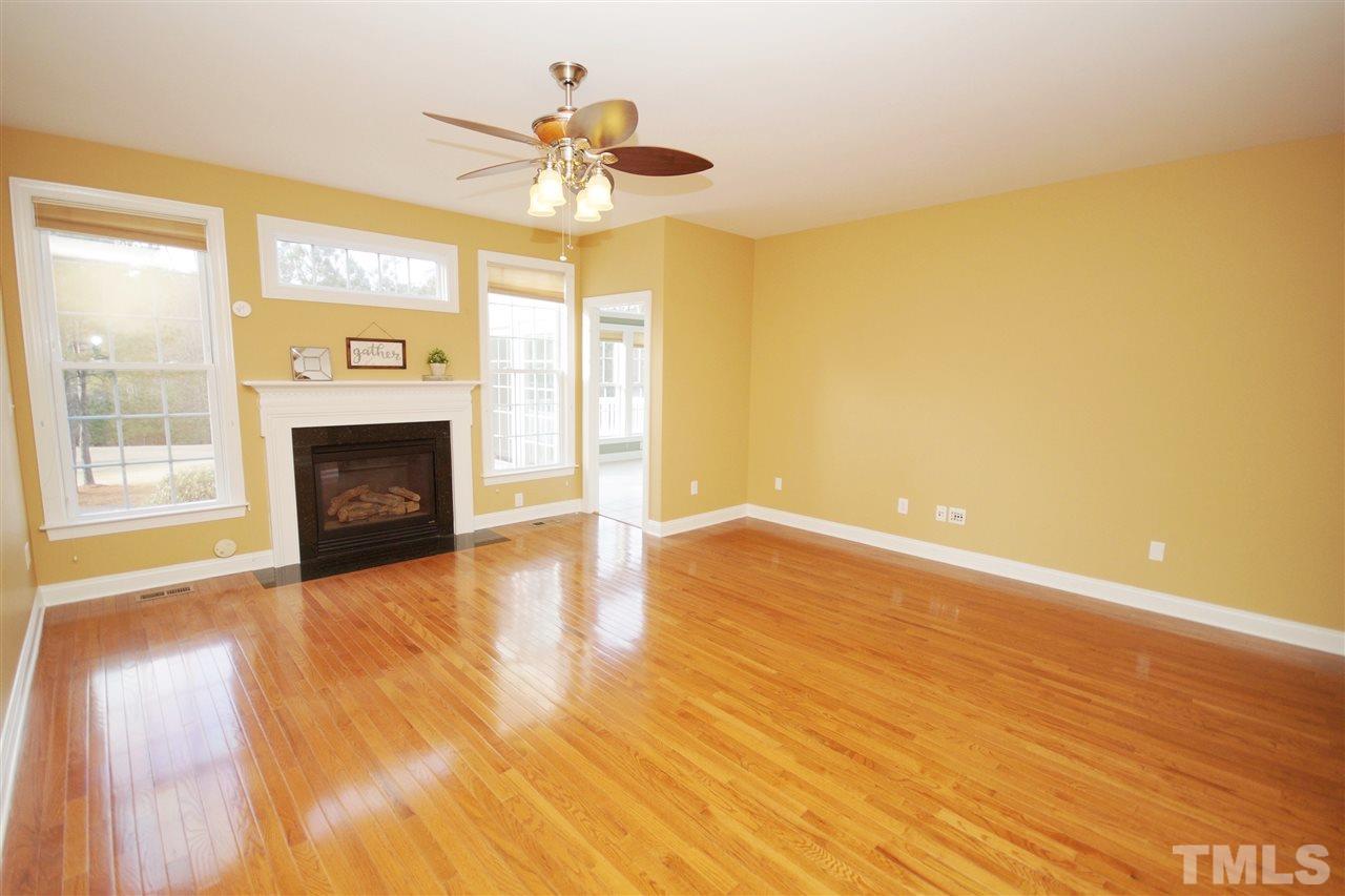11032 Fair Chase Court Raleigh, NC 27617 - Photo 8 of 25 a view of empty room with wooden floor and a fireplace