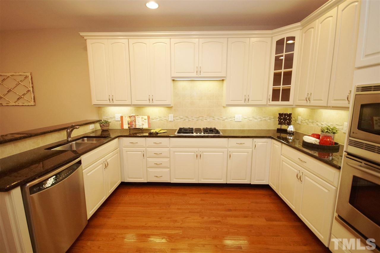 11032 Fair Chase Court Raleigh, NC 27617 - Photo 10 of 25 a kitchen with a refrigerator sink and cabinets