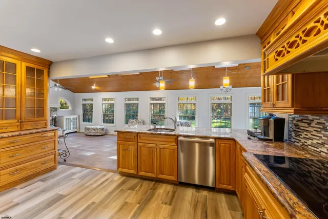a view of a kitchen with stainless steel appliances granite countertop a stove and a wooden floors