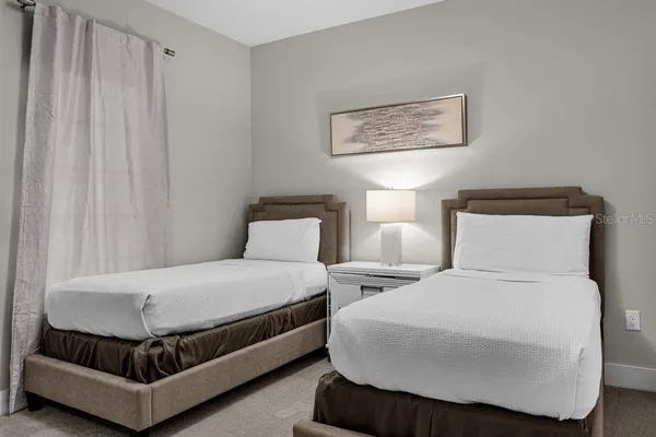 a bedroom with bed and a painting on the wall
