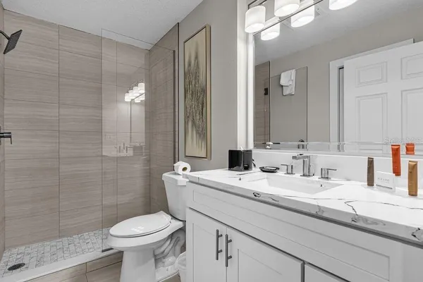 a bathroom with a sink a toilet and shower