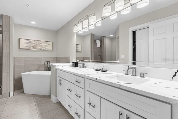 a bathroom with a double vanity sink a mirror and a bathtub