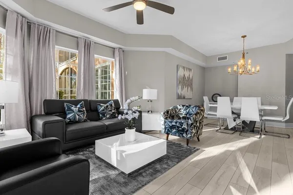 a living room with furniture chandelier and a large window