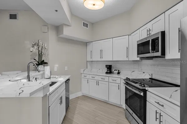 a kitchen with stainless steel appliances granite countertop a sink and stove top oven