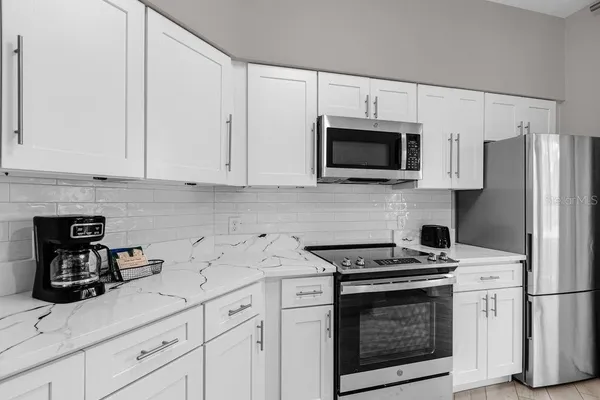a kitchen with white cabinets and stainless steel appliances