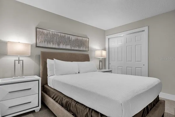 a bedroom with a bed and a night stand