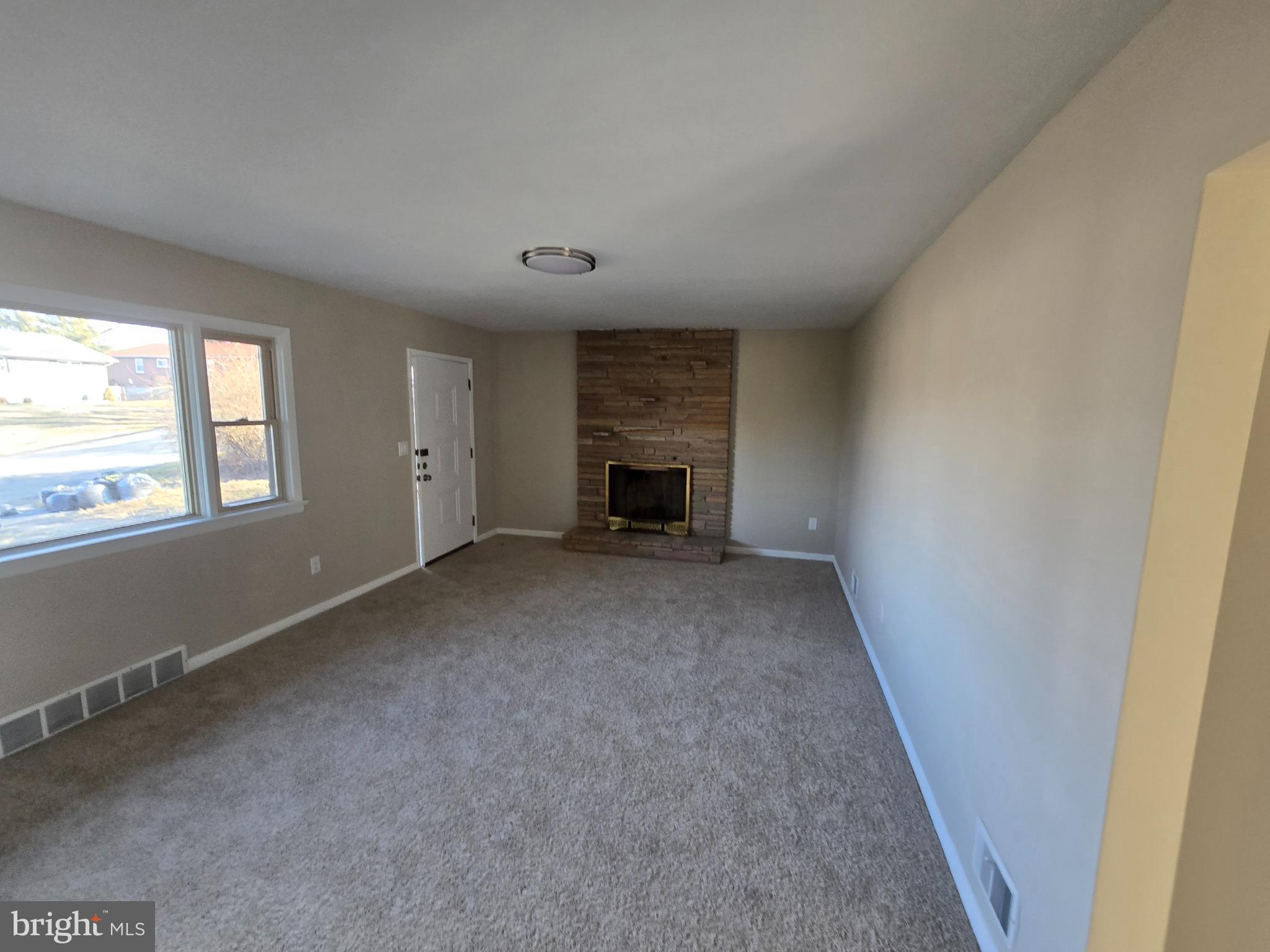 17721 Timberlane Hagerstown, MD 21740 - Photo 5 of 27 an empty room with a fireplace and windows