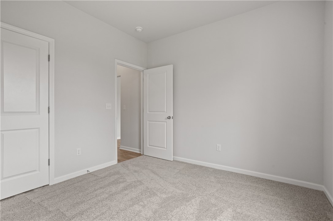555 Hydrangea Street, Unit LOT 47 Seneca, SC 29678 - Photo 18 of 38 An inviting room boasts fresh, clean carpet flooring and well-maintained walls, awaiting your personal touch.
