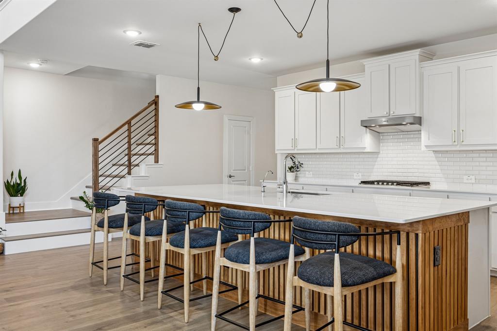 425 Breeds Hl Road Little Elm, TX 75068 - Photo 7 of 38 a kitchen with a dining table chairs sink and white cabinets