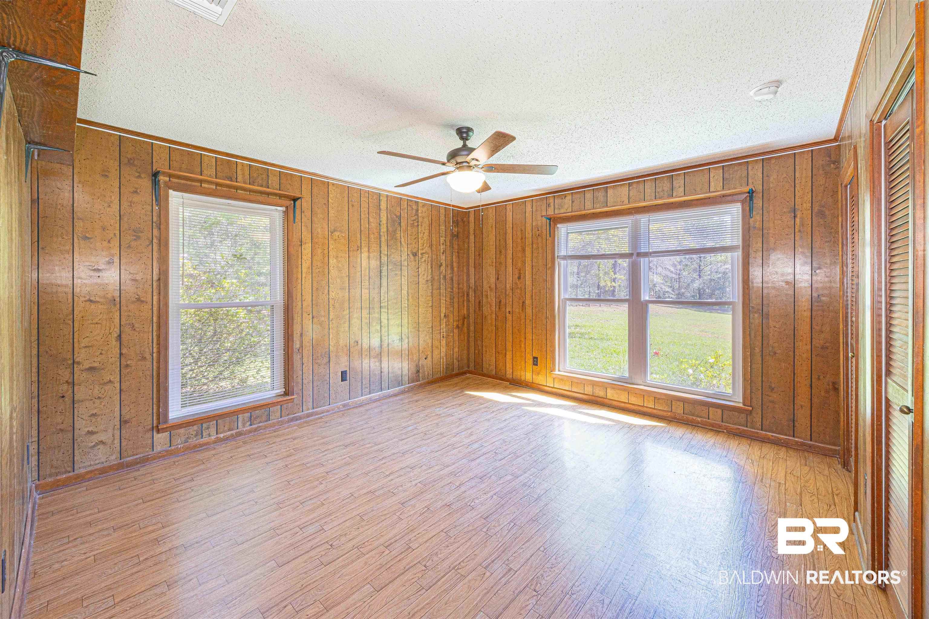 43101 Brown Road Bay Minette, AL 36507 - Photo 36 of 81 Bedroom featuring light wood finished floors, healthy amount of natural light, ceiling fan, wooden walls, and a textured ceiling