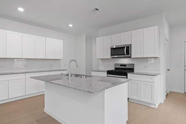 a kitchen with appliances a sink and cabinets