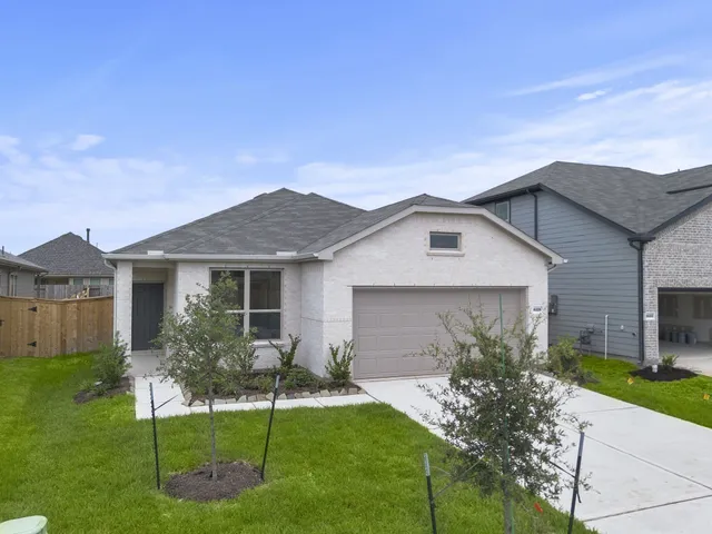 a front view of a house with a yard and potted plants