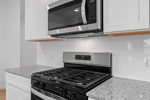 a stove top oven sitting inside of a kitchen