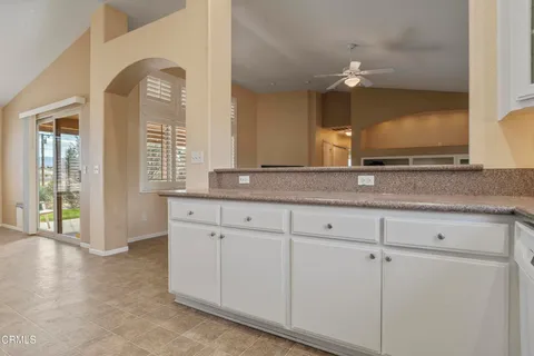 a view with granite countertop cabinets and a large window