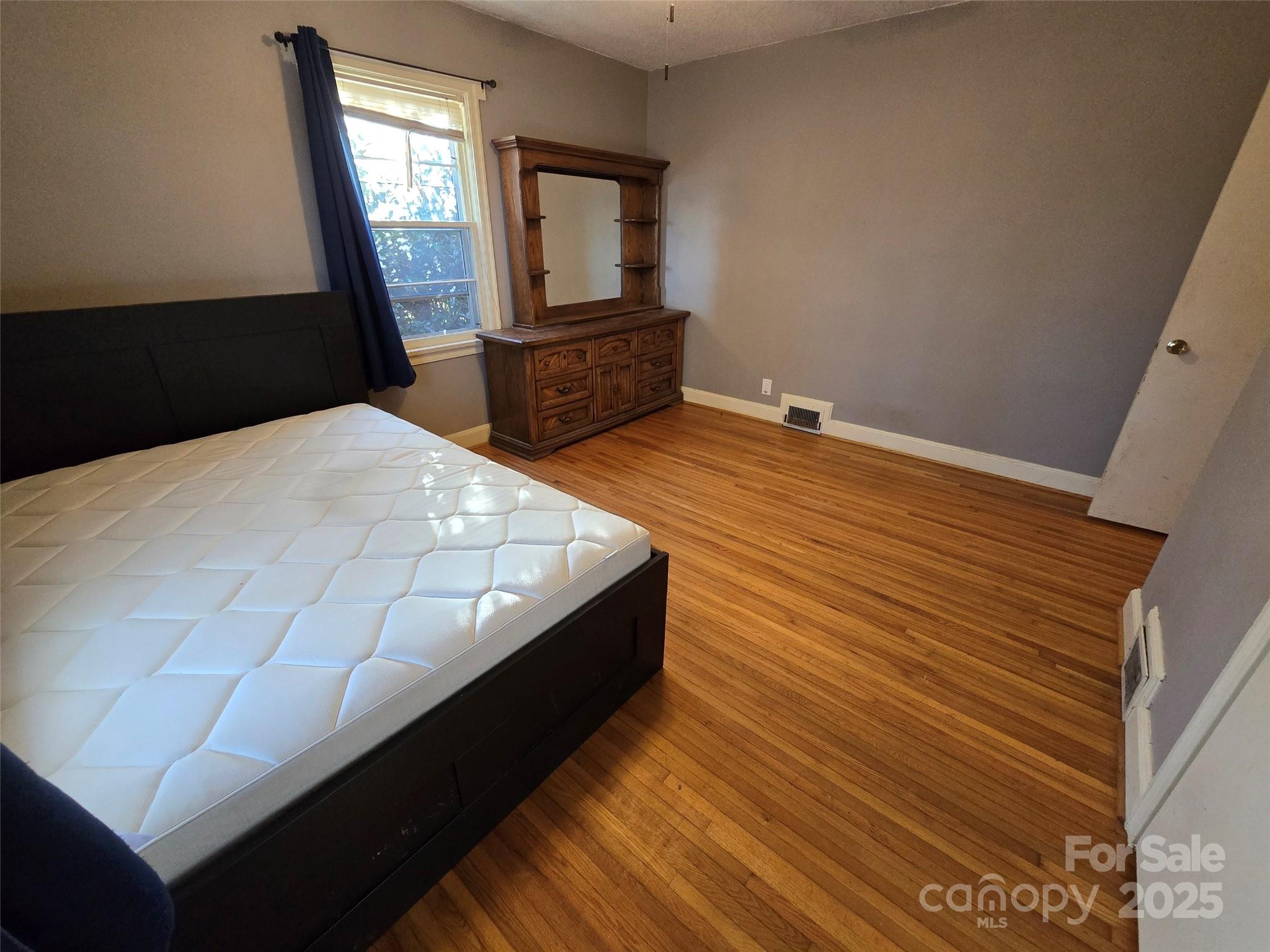 160 Williamson Street Troy, NC 27371 - Photo 14 of 24 a bedroom with a bed lamp and mirror on the dresser