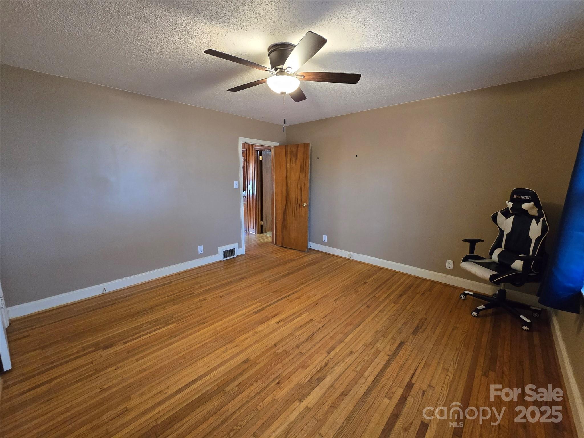 160 Williamson Street Troy, NC 27371 - Photo 17 of 24 a view of a room with wooden floor and a ceiling fan