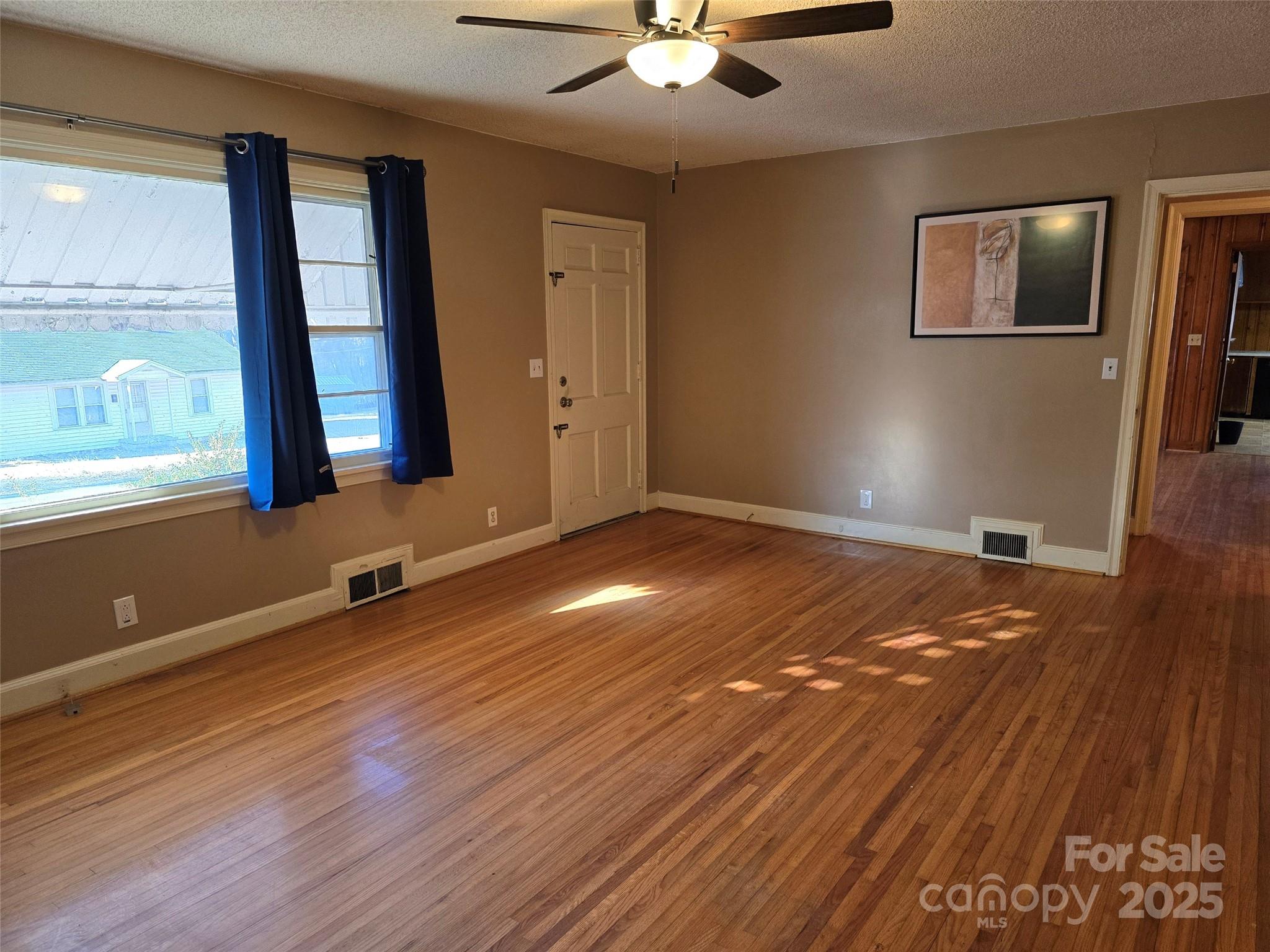 160 Williamson Street Troy, NC 27371 - Photo 3 of 24 a view of an empty room with wooden floor and a window
