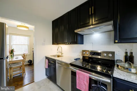 a kitchen with stainless steel appliances a stove a sink dishwasher and cabinets with wooden floor