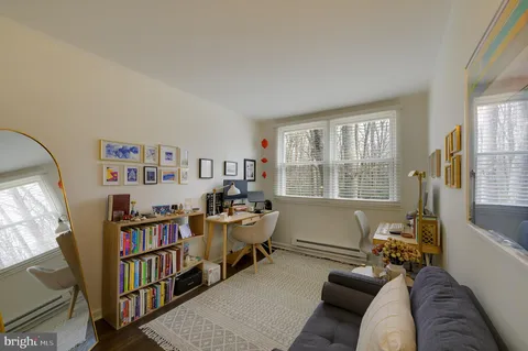 a living room with furniture a bookshelf and a window