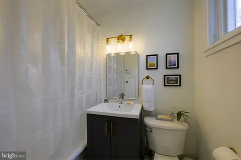 a bathroom with a toilet a sink and mirror