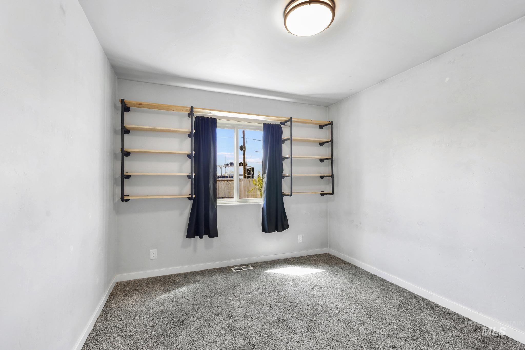 826 Normal Burley, ID 83318 - Photo 14 of 21 Bedroom featuring a window with built-in shelving, plush gray carpeting, and light-colored walls