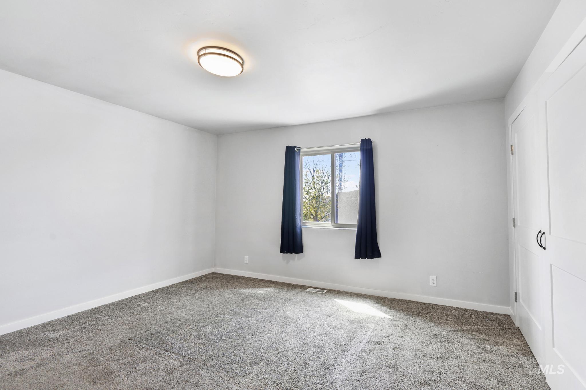 826 Normal Burley, ID 83318 - Photo 16 of 21 Spacious room featuring neutral carpeting and white baseboards