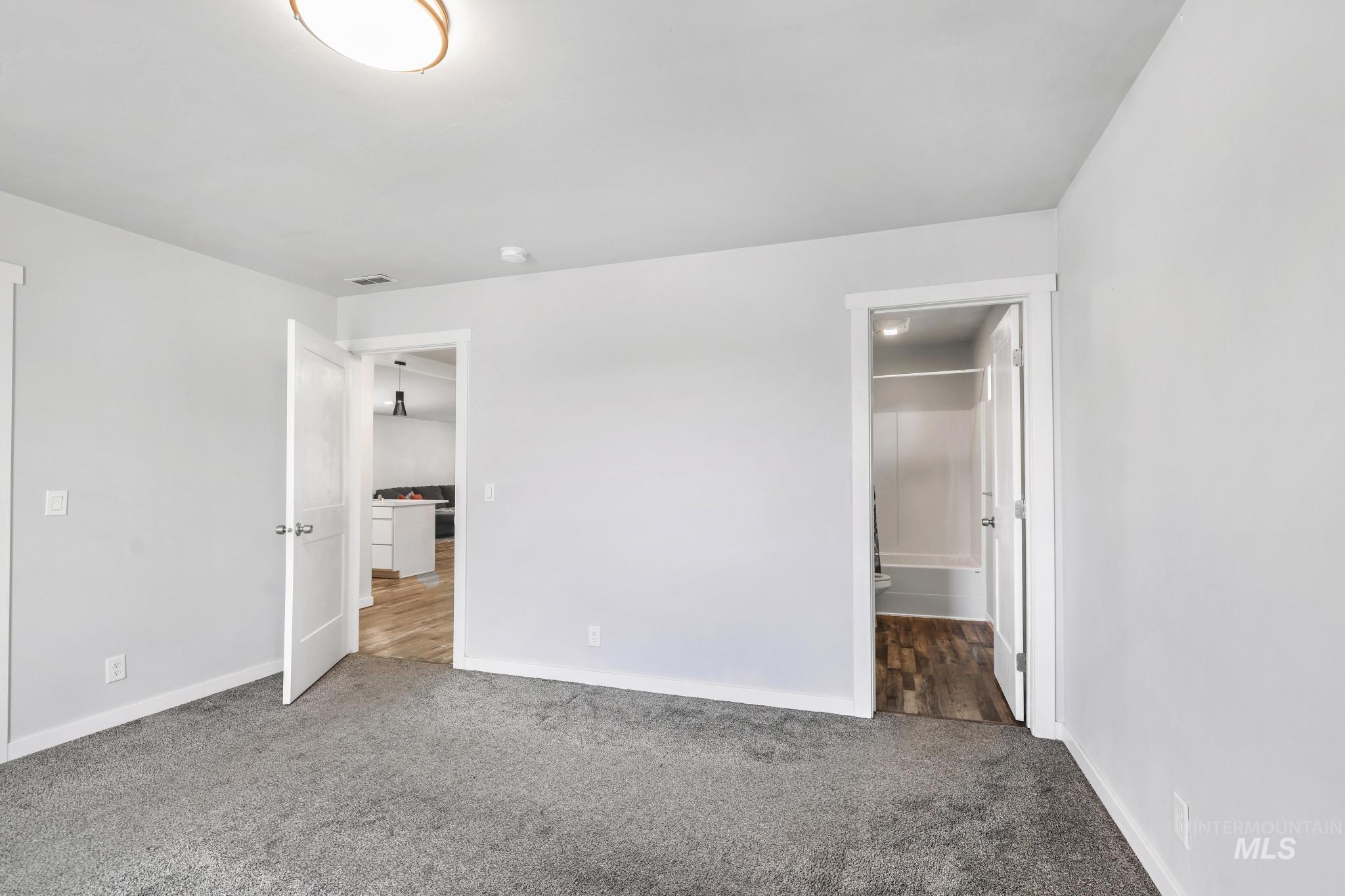 826 Normal Burley, ID 83318 - Photo 17 of 21 Spacious room featuring plush gray carpeting, crisp white walls, and a modern ceiling light fixture