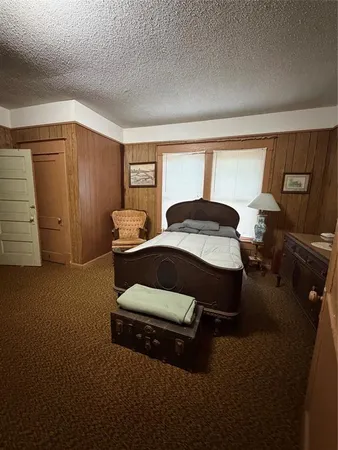 a bedroom with a bed wooden floor and windows