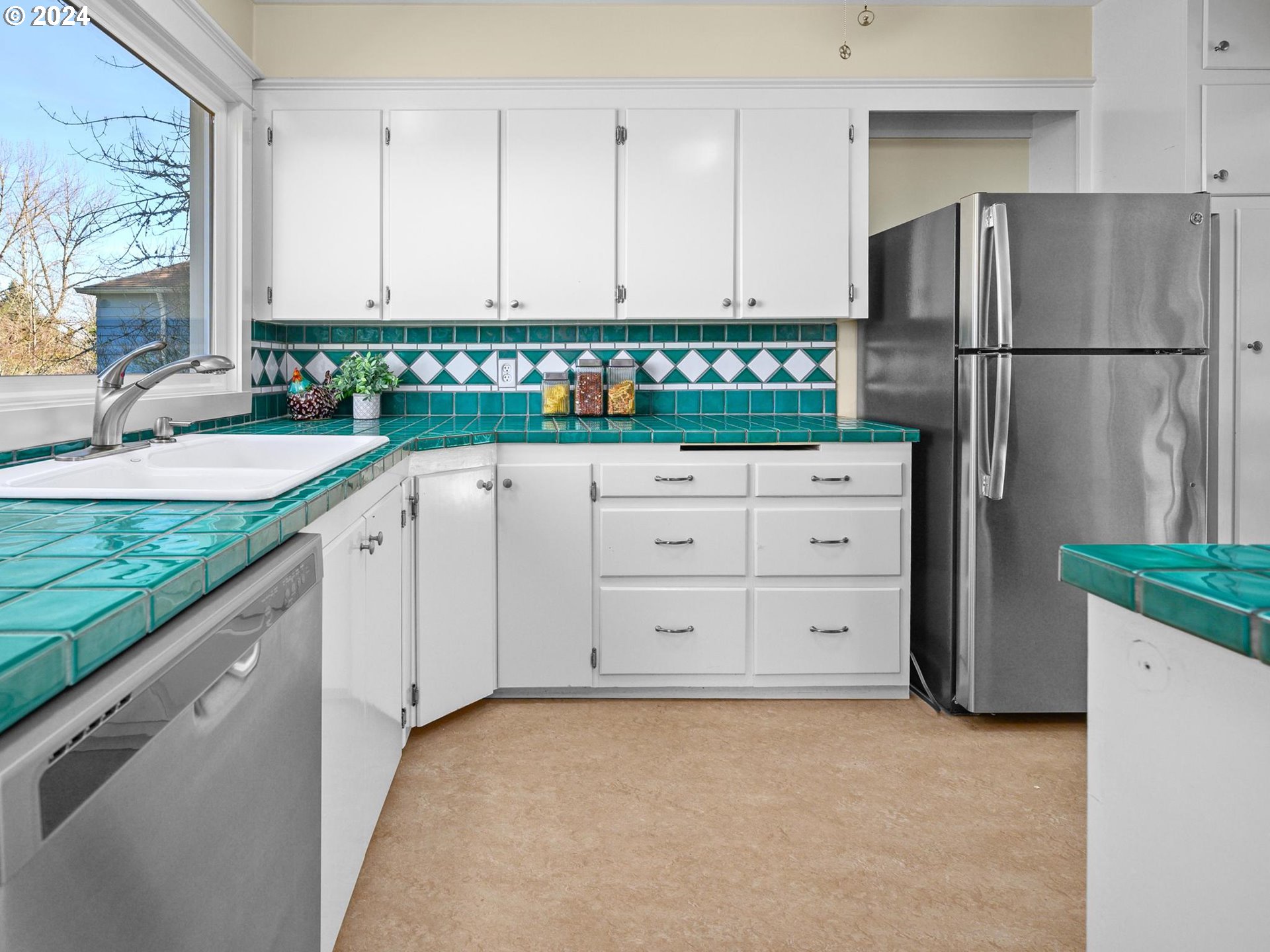 6435 Southwest Brugger Street Portland, OR 97219 - Photo 12 of 43 a kitchen with granite countertop a refrigerator and a sink