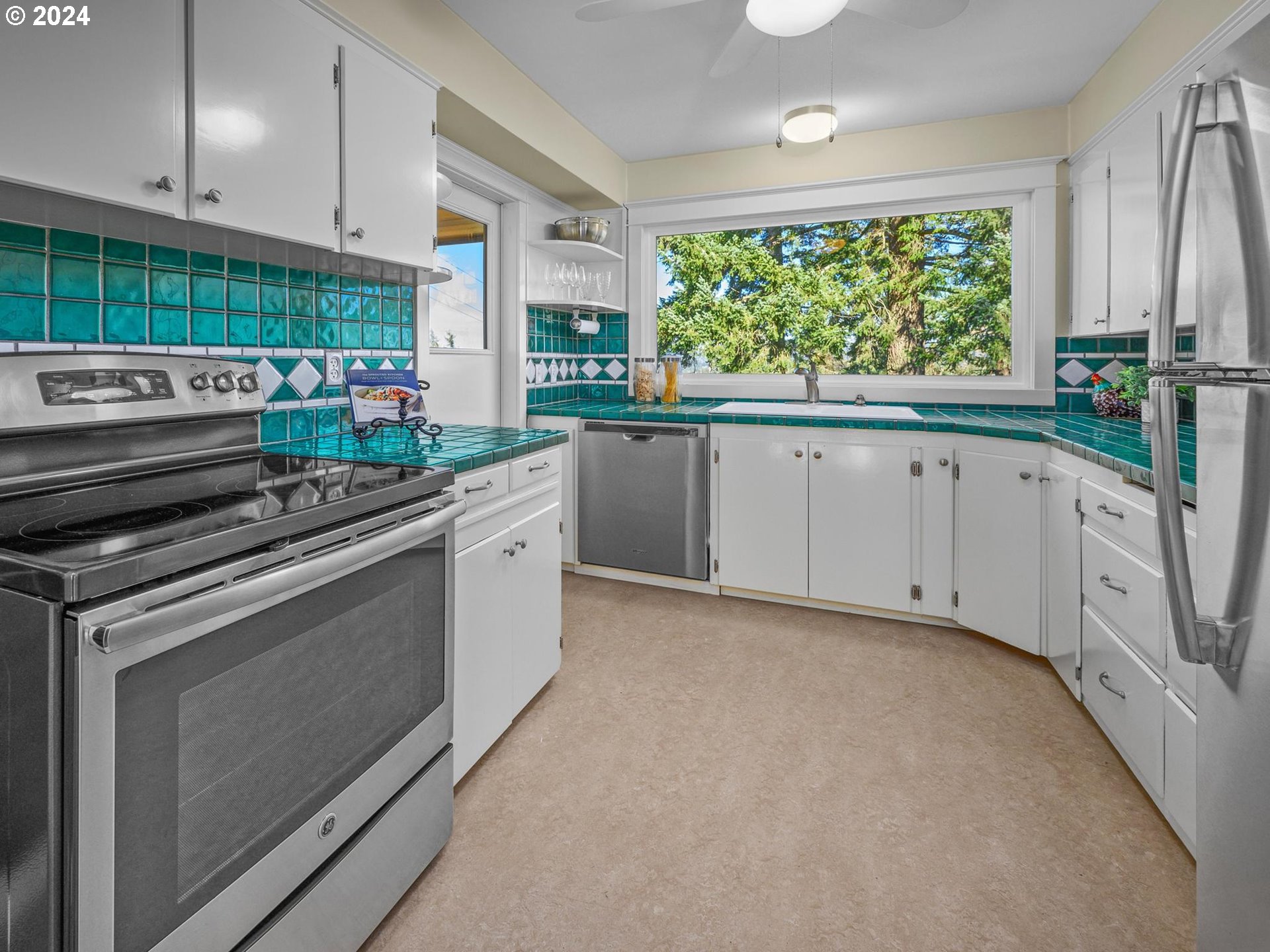 6435 Southwest Brugger Street Portland, OR 97219 - Photo 13 of 43 a kitchen with a stove a sink and a window