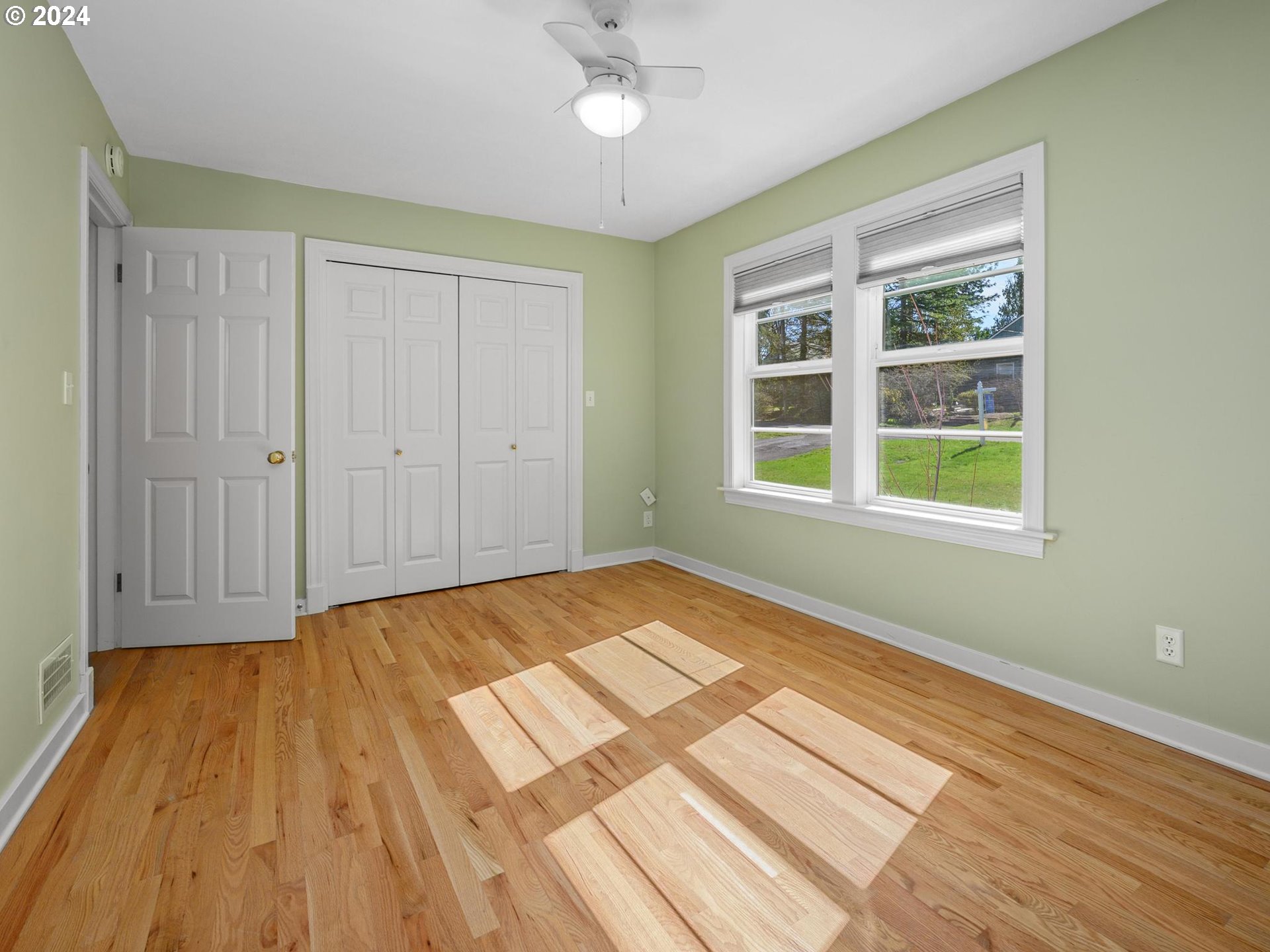 6435 Southwest Brugger Street Portland, OR 97219 - Photo 24 of 43 a view of an empty room with wooden floor and a window