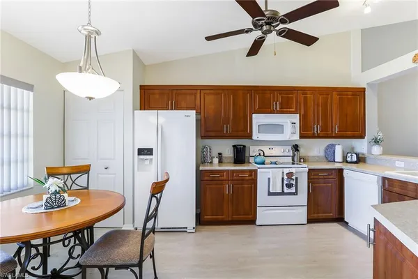 a kitchen with stainless steel appliances a table chairs and a refrigerator