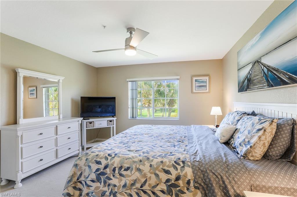 9022 Michael Circle, Unit 4 Naples, FL 34113 - Photo 15 of 28 a bedroom with a bed and a flat screen television