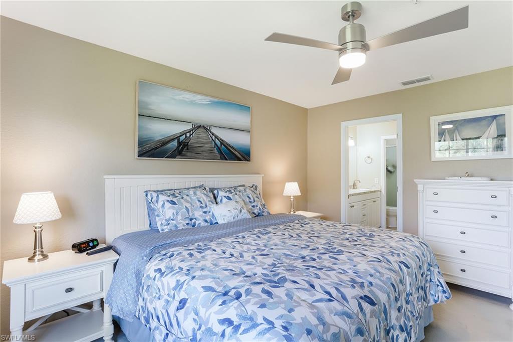 9022 Michael Circle, Unit 4 Naples, FL 34113 - Photo 16 of 28 a bedroom with a bed and a chandelier