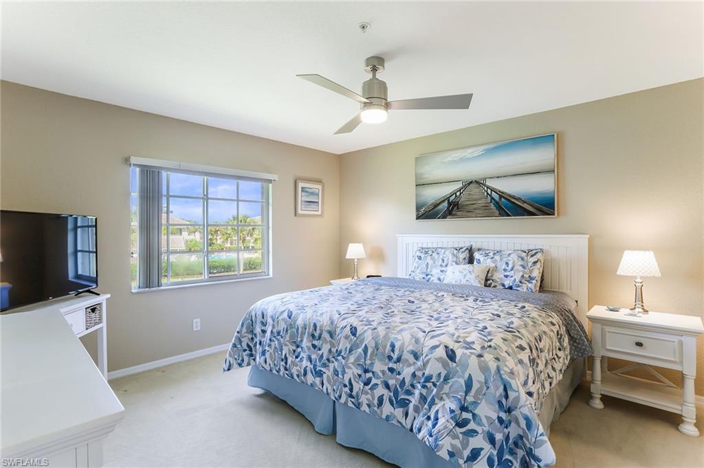9022 Michael Circle, Unit 4 Naples, FL 34113 - Photo 17 of 28 a bedroom with a bed and a flat screen tv