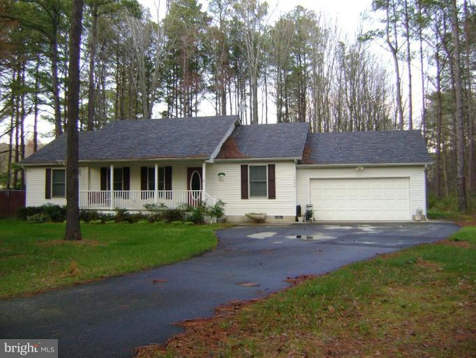 17868 Piney Point Road Tall Timbers, MD 20690 - Photo 1 of 13 a front view of a house with a garden and trees