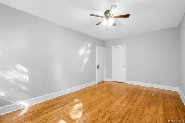 a view of a big room with wooden floor and a chandelier fan