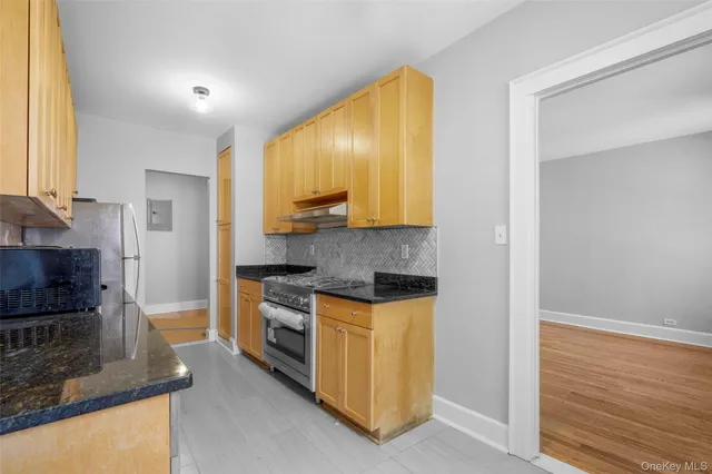 a kitchen with stainless steel appliances granite countertop a stove a sink and a refrigerator