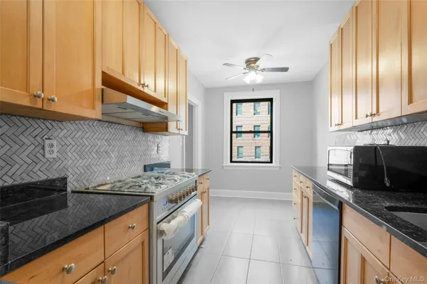 a kitchen with stainless steel appliances granite countertop a sink stove and cabinets