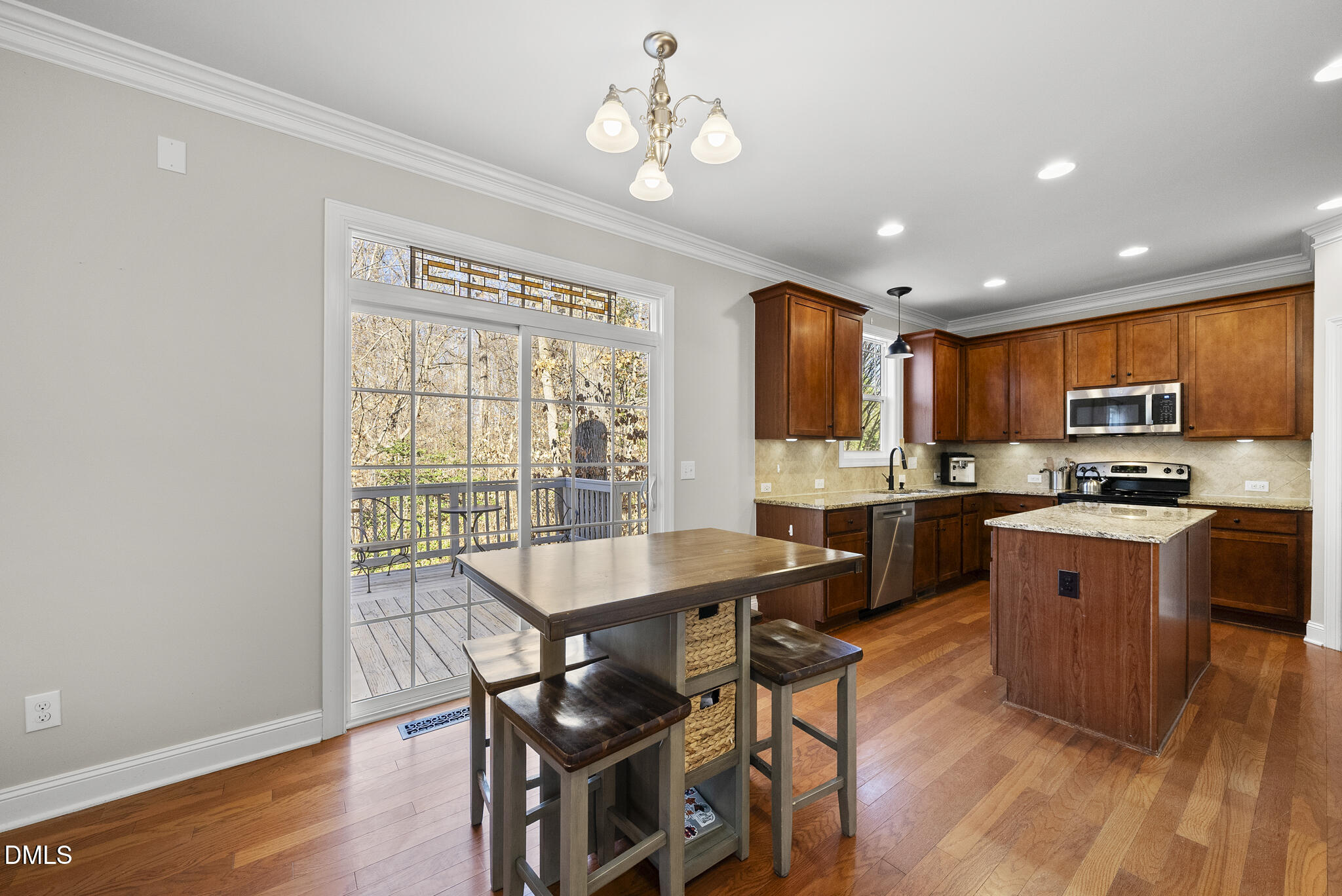 2731 Hidden Waters Circle Raleigh, NC 27614 - Photo 19 of 58 a kitchen with stainless steel appliances granite countertop a stove top oven a sink dishwasher a dining table and chairs with wooden floor