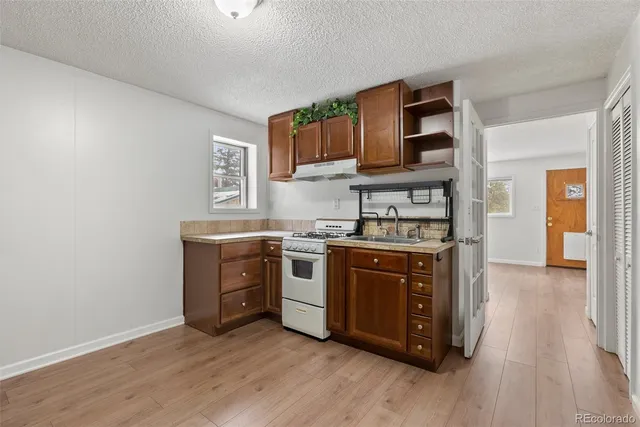 a kitchen with stainless steel appliances kitchen island granite countertop a table chairs and a refrigerator