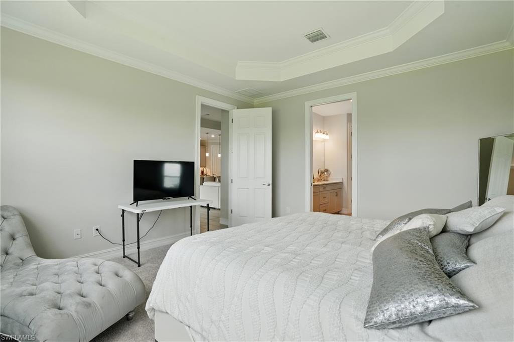 28165 Captiva Shell Loop Bonita Springs, FL 34135 - Photo 16 of 38 a bedroom with a bed and a flat screen tv