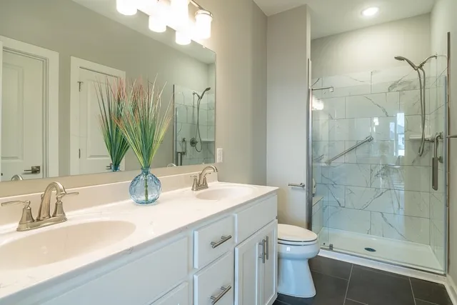 a bathroom with a sink a toilet and shower