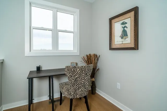 a view of a workspace with furniture and a window