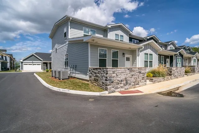 a view of a house with a small yard and potted plants
