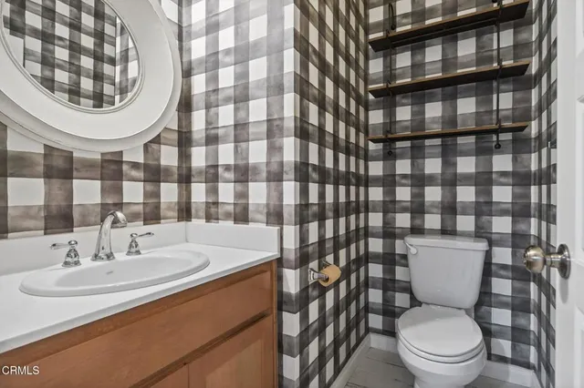 a bathroom with a sink a toilet and a mirror