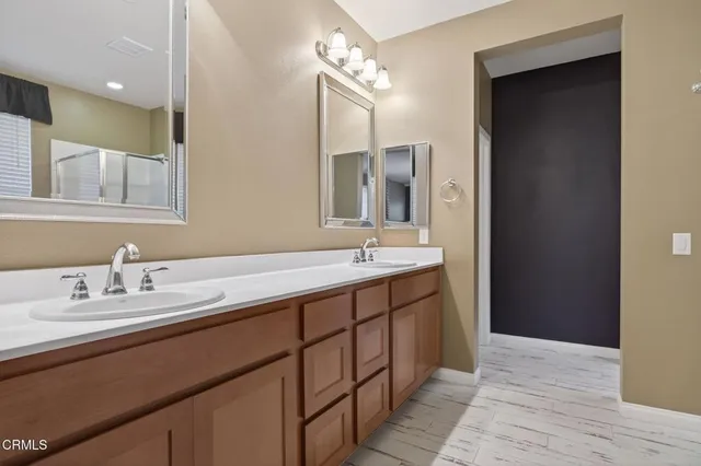 a bathroom with a double vanity sink and a mirror