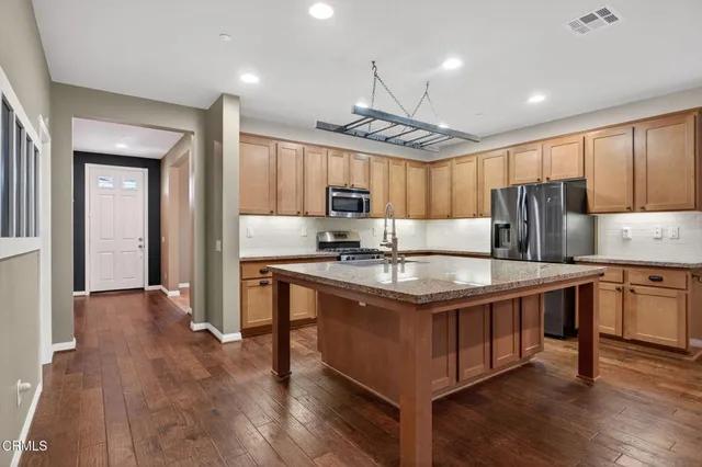 a kitchen with stainless steel appliances granite countertop a sink stove and refrigerator